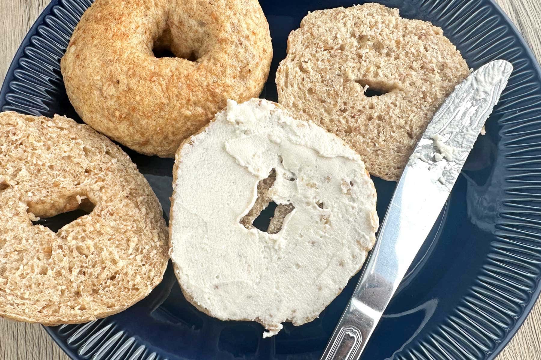 24 Breakfast Recipes That Are Simple, Flavorful, and Delicious 1 Homemade multi grain bagels with a crispy crust on a dark serving plate.
