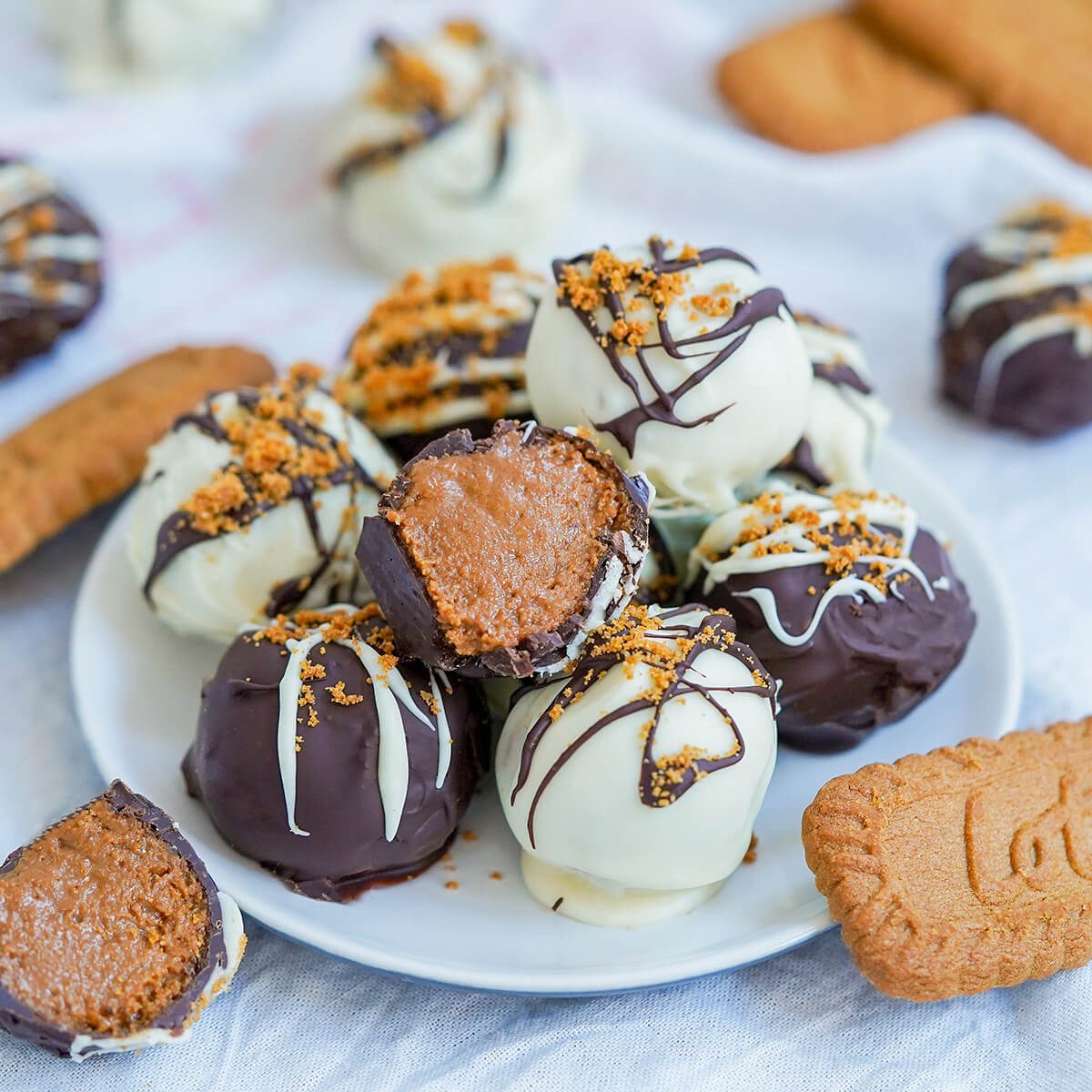 Biscoff truffles - Caroline's Cooking 1 small plate of biscoff truffles with one cut sitting on top.