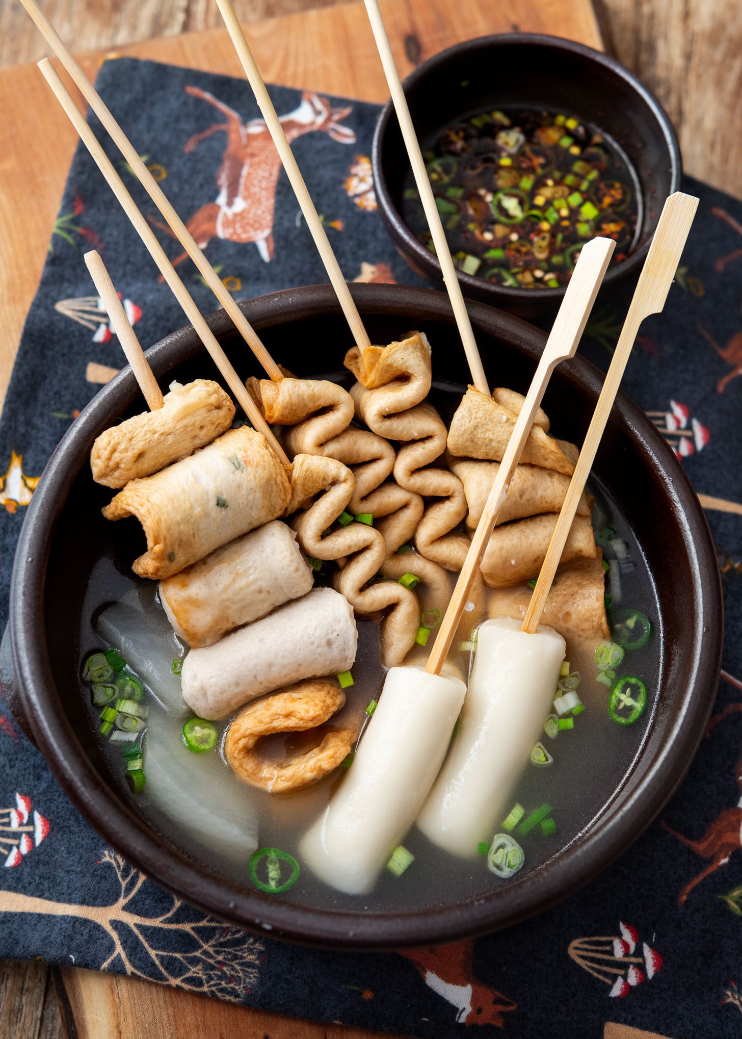 Korean Fish Cake Soup (Odeng Guk) 28 Skewered fish cakes (eomuk) served in a light Korean broth and a small bowl of dipping sauce on the side.