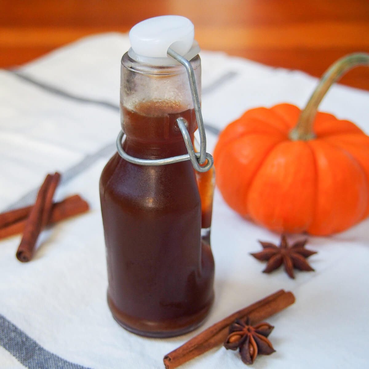 Pumpkin spice syrup - Caroline's Cooking 5 bottle of homemade pumpkin spice syrup with mini pumpkin behind